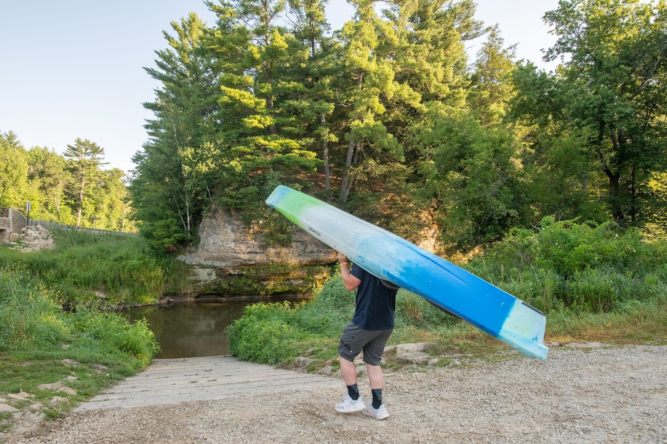 A man bringing a kayak to the kickapoo river